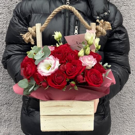 The composition in a box of red roses, eastoma and eucalyptus