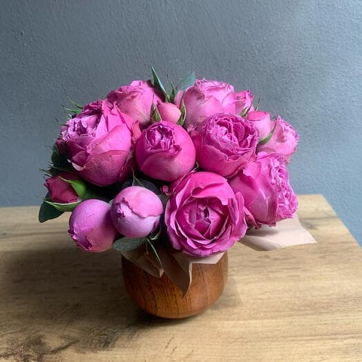 Mini composition of pionivate bush rose with eucalyptus in a cedar cup