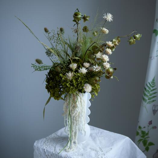Interior bouquet of stabilized plants and dried flowers in a ceramic vase