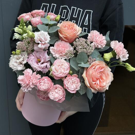Bouquet of bush roses, eastomas and dianthuses in a hat box