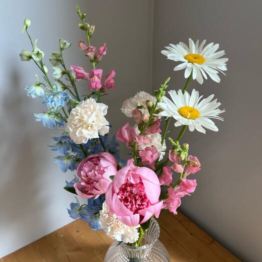 Interior bouquet with peonies of daisies Delphiniums Dianthus and lion's yawn
