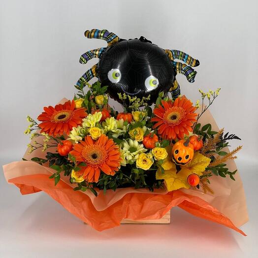 Wooden pot with flowers and a black spider