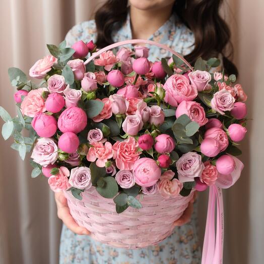 Flowers basket, delicate composition of pink peonies of roses and a bush rose with eucalyptus twigs