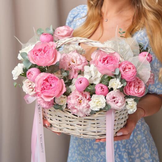 Basket with flowers. Stylish composition with pionoid roses Snow -white hydrangea glass leaves and twigs of eucalyptus