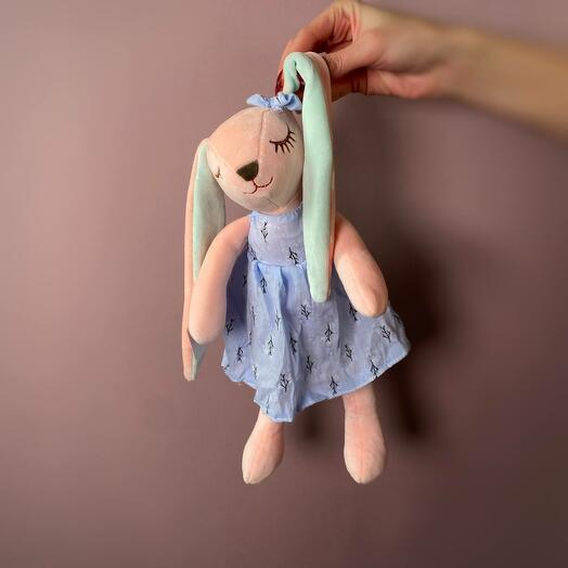 Soft toy pink bunny in a blue dress