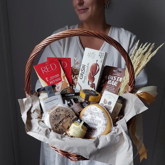 Sanding-golden grocery basket. Chocolate, cookies, cheese, honey, paste and sauce