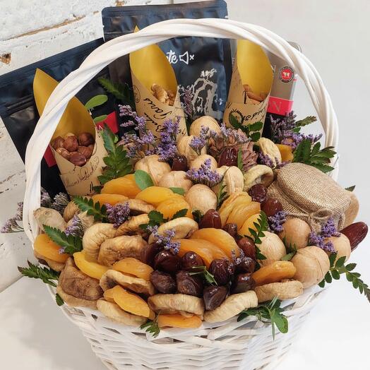 A basket with tea, chocolate, honey, nuts and dried fruits