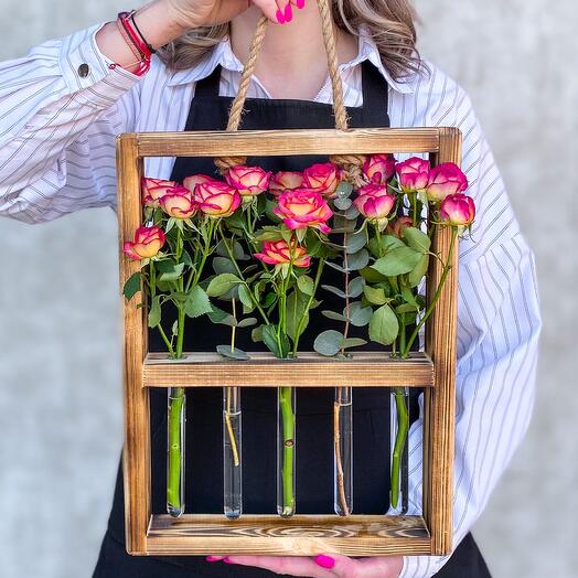 Frame with flasks red-yellow roses and eucalyptus